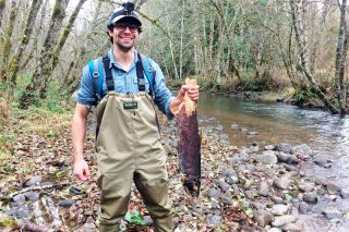 Submitted photo ##Oregon State University graduate Andrew Chione, a Native Fish Society river steward in the Yamhill Watershed, holds up a coho salmon carcass found on the Upper North Yamhill River.