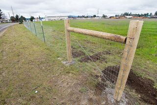 Marcus Larson / News-Register##Dean Klaus, owner of the vacant lot across from Yamhill Community Action Partnership, is having a fence built between his property and the people camping in tents and RVs along Dustin Court.