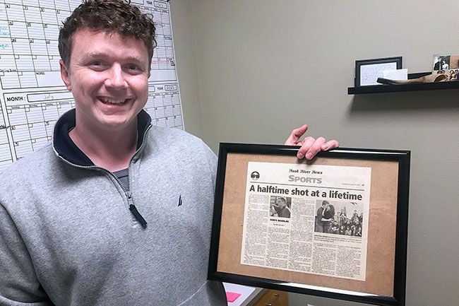 Kirby Neumann-Rea/News-Register##Jake Johnson holds the Dec. 25, 2010 newspaper article about his halftime proposal to his wife, Christina Brown, a fellow graduate of Horizon Christian School in Hood River.