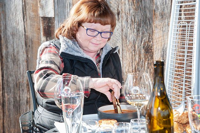 Rusty Rae/News-Register##Jeri Harris of McMinnville dips her Melt Down grilled cheese sandwich into tomato bisque prepared by Brooks Wines chef Norma Buchholz.