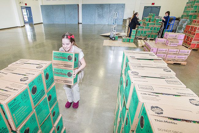 Marcus Larson/News-Register##Girl Scout Grace Garand helps gather the correct amount of cookie boxes for another troop s orders. Nearly 39,000 boxes of cookies arrived in Yamhill County Friday.