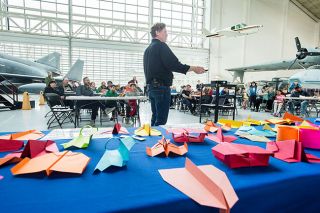 Marcus Larson/News-Register##
John Collins demonstrates a paper airplane so light and thin that he can keep it spinning in midair indefinitely by forcing air to flow upward with his hands while he walks forward. Marcus Larson/News-Register##
John Collins demonstrates a paper airplane so light and thin that he can keep it spinning in midair indefinitely by forcing air to flow upward with his hands while he walks forward.