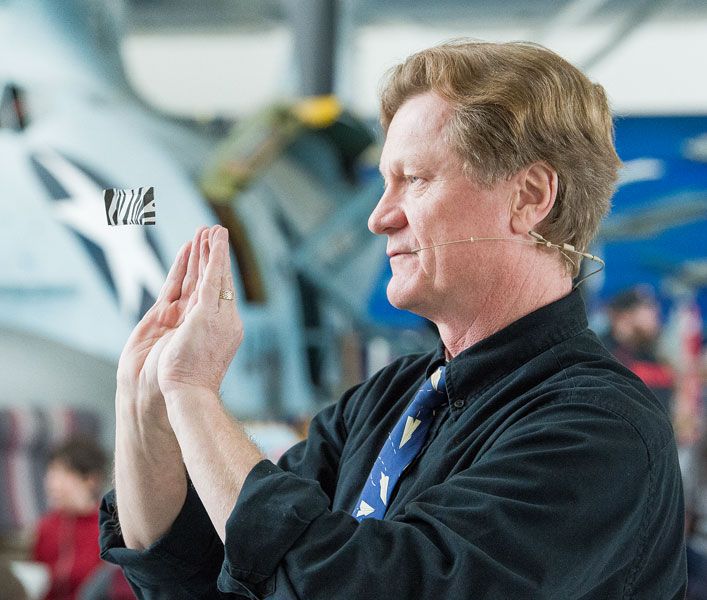 Marcus Larson/News-Register##
John Collins demonstrates a paper airplane so light and thin that he can keep it spinning in midair indefinitely by forcing air to flow upward with his hands while he walks forward.