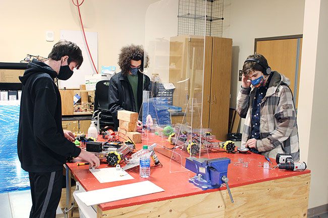 Submitted photos##Logan Shurts, Dane Foster and Cyrus Scarboro-Ford work on the robot their teacher designed for a recent competition. Robotics teams have been meeting in small groups at Mac High since fall.