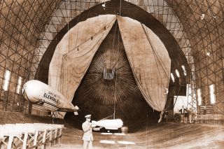Image: Slate Aircraft Co.##Thomas B. Slate inspects a scale model in the hangar that housed his full-sized airship.