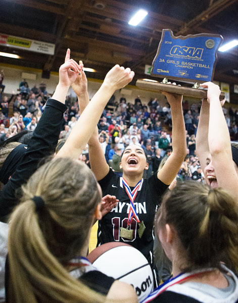 Rockne Roll/News-Register##
Kalina Rojas, center, and other Dayton players lift the championship trophy following their victory in the Class 3A Basketball State Championship against Salem Academy March 3 at the Pirate Palace in Coos Bay.