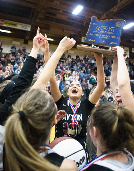 Rockne Roll/News-Register##
Kalina Rojas, center, and other Dayton players lift the championship trophy following their victory in the Class 3A Basketball State Championship against Salem Academy March 3 at the Pirate Palace in Coos Bay.