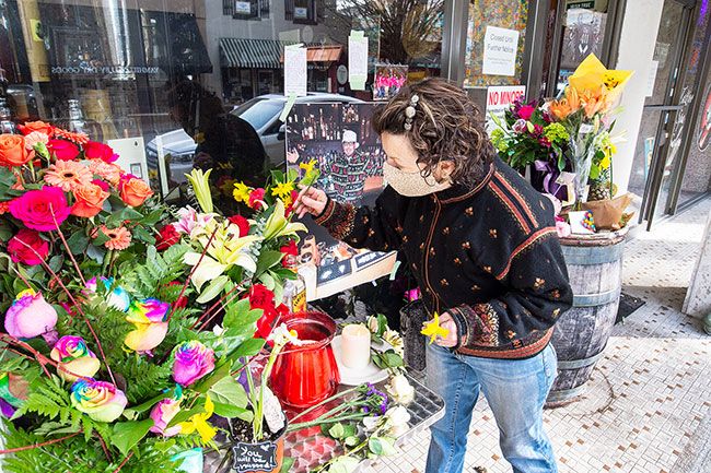 Marcus Larson/News-Register## Kathleen McKinney places daffodils on the memorial for 411 Eatery and lounge owner Rick Drakely who died unexpectedly over the weekend. Like so many others, McKinney has fond memories of Drakely. She described how hard he was trying to make the restaurant succeed during trying times.  He wasn t going to give up,  McKinney said.  He was going to make sure 411 survived, but now I m not sure what s going to happen. 