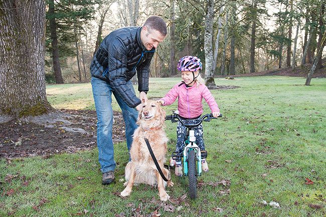 Rusty Rae/News-Register##
Ron Baker helps 4-year-old daughter Eleanor with their dog Sandy at one of the possible sites for a pump track in McMinnville City Park across the parking lot from the pickleball courts off Northwest Star Mill Way. Pump tracks give cyclists enough momentum to perform various feats without having to pedal.