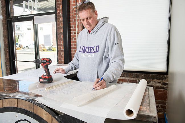 News-Register file photo##Dave Queener works on remodel plans for the building at 401 N.E. Evans St., where Two Dogs Taphouse, owned by Dave and his wife, Jami, reopened in September.