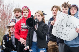 Rusty Rae/News-Register##Kassidy Fuller uses a megaphone to tell Dayton High School students about AD/Dean of Students Josh Crawfod at a rally Tuesday morning. She is flanked by Gavin Koch, left, and Kallen Lindell with sign, and other classmates.