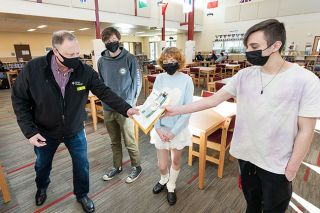 Marcus Larson/News-Register##First Federal President Jim Schlotfedlt hands out awards to McMinnville High School students Klaus Zimmerling, Savannah Thompson and Ethan Thom, recognizing their excellent work in their economics and personal financial class.