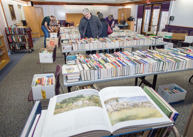 Marcus Larson/News-Register ## Mike Graham  and others browse the large selection of books during a recent book sale in the Carnegie Room at the McMinnville Library.