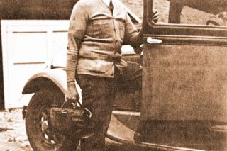 Image: E.R. Huckleberry ## Dr. E.R. Huckleberry, with his doctor’s bag and Hudson automobile-ambulance. After trying other makes of vehicles, he found the Hudson the most durable.