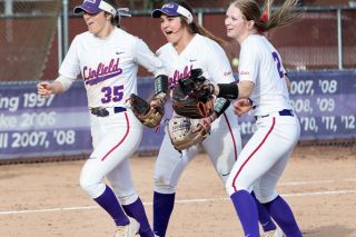 Marcus Larson/News-Register##
Linfield softball players Katie Phillips, Katrina Johns and Tayah Kelley celebrate Phillips’ amazing outfield assist during the fourth inning of Friday’s game against Whitworth. Phillips threw out a Pirate runner at the plate to preserve the 5-0 shutout.