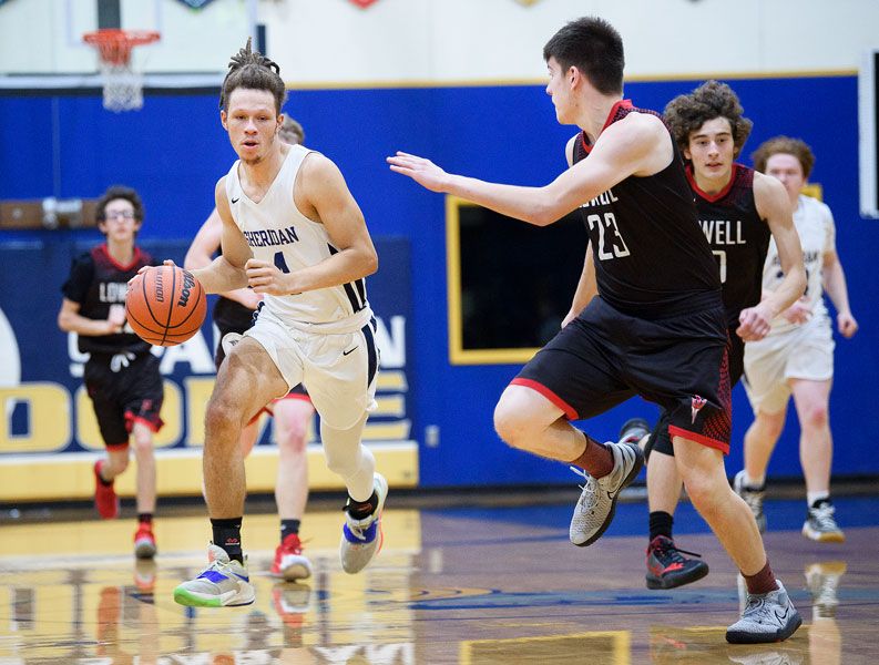 Rusty Rae/News-Register file photo##
Sheridan senior forward Randy Gibson dribbles the ball into the frontcourt during the Spartans’ non-conference contest against Lowell last December. Gibson recently earned second team, all-Tri-River Conference honors.