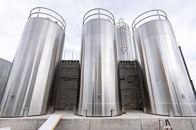 Marcus Larson/News-Register ##  Three 10,000-gallon tanks, prominent landmarks along Highway 99W that were spared from the 2021ire, refinished and repaired.