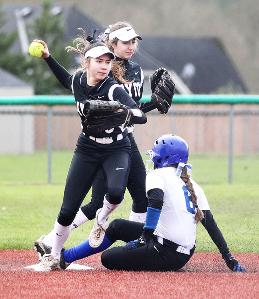 Rockne Roll/News-Register##
Dayton second baseman Gabby Shadden, front, looks to throw to first base in the first game of the Pirates’ doubleheader against Blanchet Catholic.