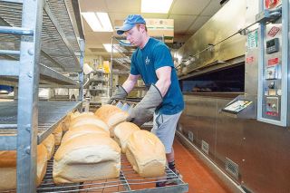 Marcus Larson/News-Register##
Great Harvest Bread Company owner Kendal Williams places fresh loaves of country white bread on a cooling rack after taking them out of the oven.