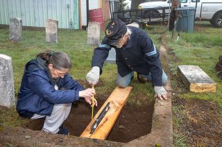 Rusty Rae/News-Register##Tim O’Neal and his wife Kathy Jo work on preparing the area for the installation of the new headstone for Civil War Veteran Isaac Cyrene Terry at the Masonic Cemetery in McMinnville.