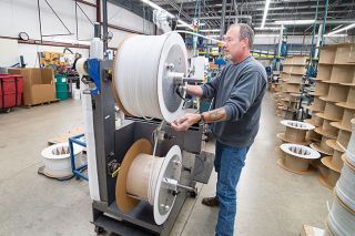 Marcus Larson/News-Register##
Freelin-Wade worker Rick Drahiem finishes up a spool of reinforced polyurethane tubing on the manufacturing line.