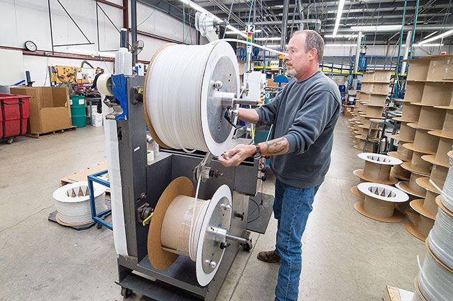 Marcus Larson/News-Register##
Freelin-Wade worker Rick Drahiem finishes up a spool of reinforced polyurethane tubing on the manufacturing line.