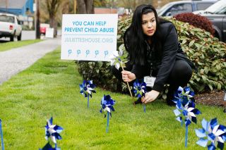 Rockne Roll/News-Register##
Lucy Diaz of Juliette s House plants a pinwheel as part of the group s Child Abuse Awareness Month Friday, April 6, at Citizens Bank in McMinnville.