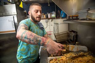 Rusty Rae/News-Register##Matt Zangara prepares JP Kloninger’s fried rice at Hawaii Five-O-Three. Zangara enjoys cooking both at work and for friends. He likes to bring ingredients to their homes and surprise them with dinner.