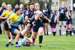 Marcus Larson/News-Register##
Valley Panther rugby player Dakota King breaks away from several Newberg defenders as she runs down the field to score the 65-yard try. King’s teammate, Mia George, sprints in support behind her.