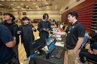 Rachel Thompson/News-Register##Miguel Santoyo of Wings & Waves Waterpark talks about potential summer employment with Dayton High juniors, from left, Eddy Munoz, Jonathan Islas and Camilo Medina during the career fair.