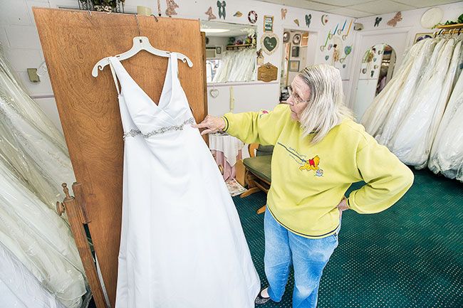 Marcus Larson/News-Register ## Juanita Layton points out sparkling embellishments on one of the formal bridal gowns in her shop.