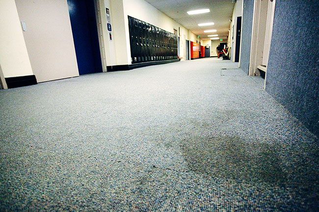 Rockne Roll/News-Register##Stained carpeting on the ground floor of Yamhill-Carlton High School’s main building, pictured Friday, April 15. The carpet was installed 20 years ago and asbestos underneath has caused it to be untouched since then.