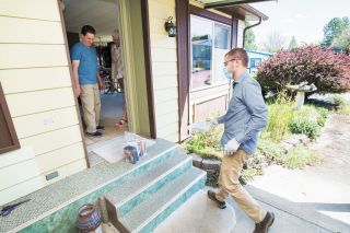 Marcus Larson / News-Register##McMinnville librarian Adam Carlson both delivers and picks up books at Curtis and Julie Robinson s house while maintaining social distancing policies.