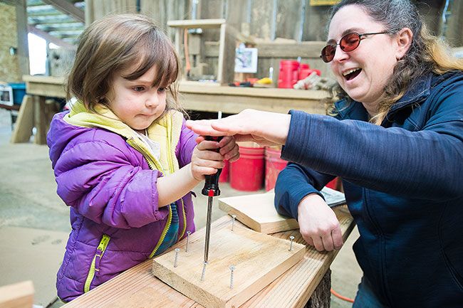 Marcus Larson/News-Register##
Shannon Carter helps her young daughter Suzanne insert screws into a panel for the birdhouse they are working on.