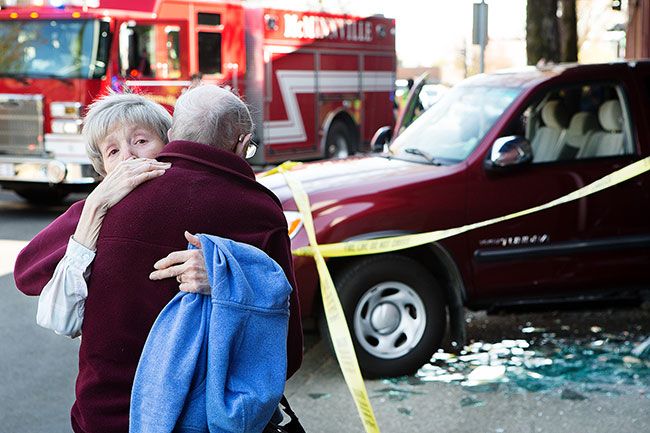 Rockne Roll/News-Register
Mildred Reppeto embraces her husband, John Reppeto, after his truck crashed into the Primisys building on Northeast Baker Street in McMinnville Sunday afternoon.