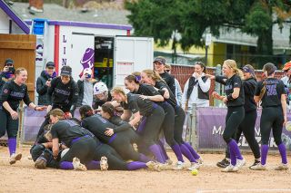 Rusty Rae/News-Register##The ‘Cats pile on top of Cydney Hess after she drives in the tournament-clinching run, celebrating a Northwest Conference tournament championship.
