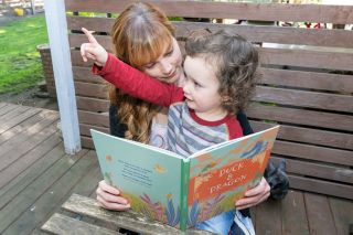 Marcus Larson/News-Register ## 
Children s book author Lisa Loo Lindman reads one of her books to her son, Cassidy, as he points out a bird in their backyard, refrencing a character in the book.