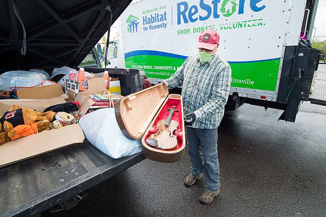 Marcus Larson/News-Register##Habitat for Humanity ReStore volunteer Barry Brown shows off a fiddle donated for the “Stuff Matters” effort supporting local nonprofits.