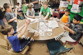 Rockne Roll/News-Register##Second graders at Grandhaven Elementary School use old editions of the News-Register in a papier rmache puppet workshop held by William Walther on Thursday, April 28.
