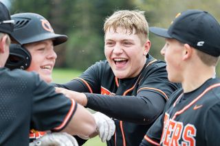 Marcus Larson/News-Register##
Yamhill-Carlton senior catcher Wyatt Hurley (center) celebrates his brother Tanner’s two-run home run during Friday’s doubleheader against Westside Christian. Wyatt later hit a home run, too, propelling the Tigers to a 25-0 victory.