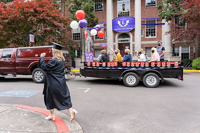 Marcus Larson/News-Register ##
Shakayla Snyder walks toward the graduation stage as her family follows close behind in a float.