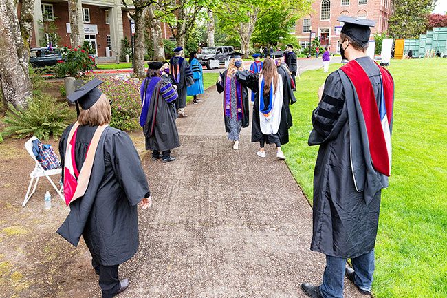 Marcus Larson/News-Register  ##
Graduate April Kelsey shares elbow bumps with Linfield professors as she makes her way through the gauntlet after receiving her diploma.