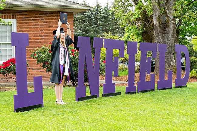 Marcus Larson/News-Register ## Graduate Amanda Reser poses for a portrait with the traditional Linfield letters after receiving her diploma.