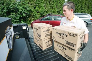 Rockne Roll/News-Register##Michai Mitchell of Les Schwab Tires in McMinnville unloads diapers collected for Lutheran Family Services at the group s office in McMinnville on Wednesday, May 4.