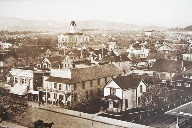 Historical photo##A building-top view of Third Street near what is now the railroad crossing shows a white wood-frame house, currently home to the Bistro Maison restaurant. In the distance is the previous Yamhill County Courthouse, built in 1889 and replaced in 1963.