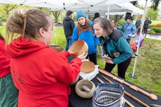 Marcus Larson/News-Register##Julie Enders and friend Katie Kulla take a closer look at a woven basket held by Tribal Collection curator Stephanie Craig of the Confederated Tribes of Grand Ronde.