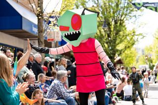 Marcus Larson/News-Register ##  An alien in a red striped tunic high-fives parade watchers.