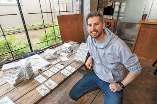 Marcus Larson/News-Register ## 
Chase Estep shows off the cards for Bandada, the new board game he created for 1 or 2 players. His game debuted recently at a party for supporters at Bierly Brewing in downtown McMinnville.