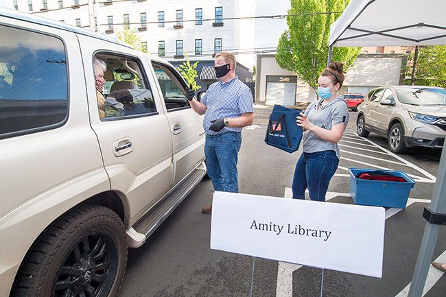 Marcus Larson/News-Register##Yamhill County Clerk Brian Van Bergen and volunteer Sara Price go through the procedure for collecting ballots with other volunteers that travel to each ballot box.