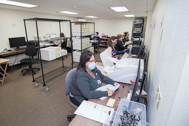 Marcus Larson/News-Register##A team of volunteers go through the slow process of adjudicating write-ins on turned in ballots.